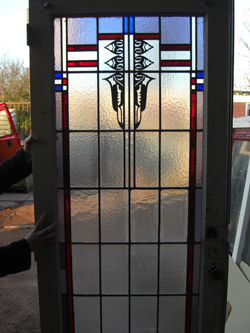 Glas-in-loodbinnendeur in Amsterdamse School-stijl, met gebrandschilderd motief.